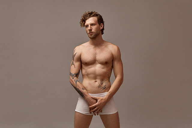 Isolated image of handsome man in underwear ready to use penis rings